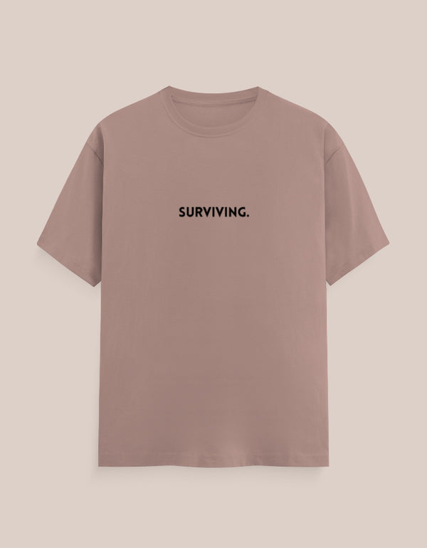 Brown t-shirt with 'SURVIVING.' text on a beige background